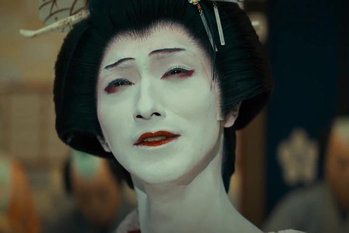 Close-up of a character in traditional makeup from Oscar nominated movies 2026, showcasing classic film costume and style.
