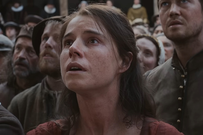 Close-up of a distressed woman among a crowd in a period drama scene from Oscar nominated movies 2026.