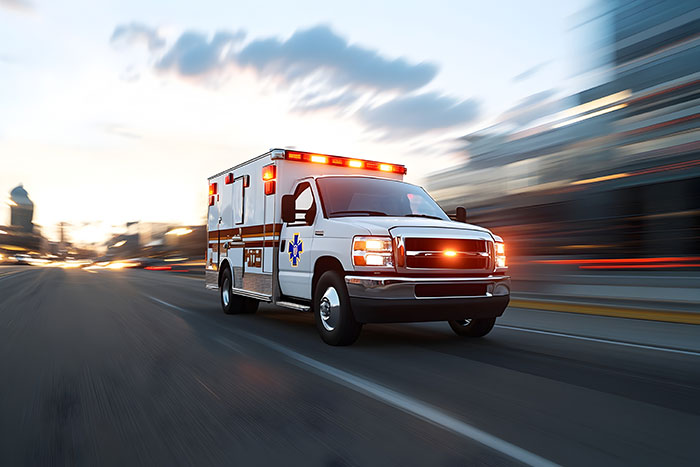 Ambulance with flashing lights speeding through city street, representing patients helping doctors and nurses.