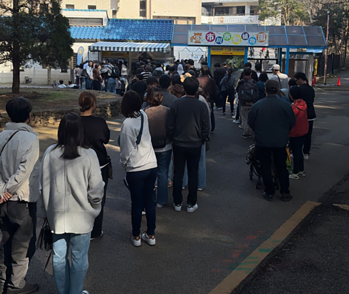 People standing in a long queue outside a booth, related to the heartbreaking video of baby monkey with stuffed toy viral story.