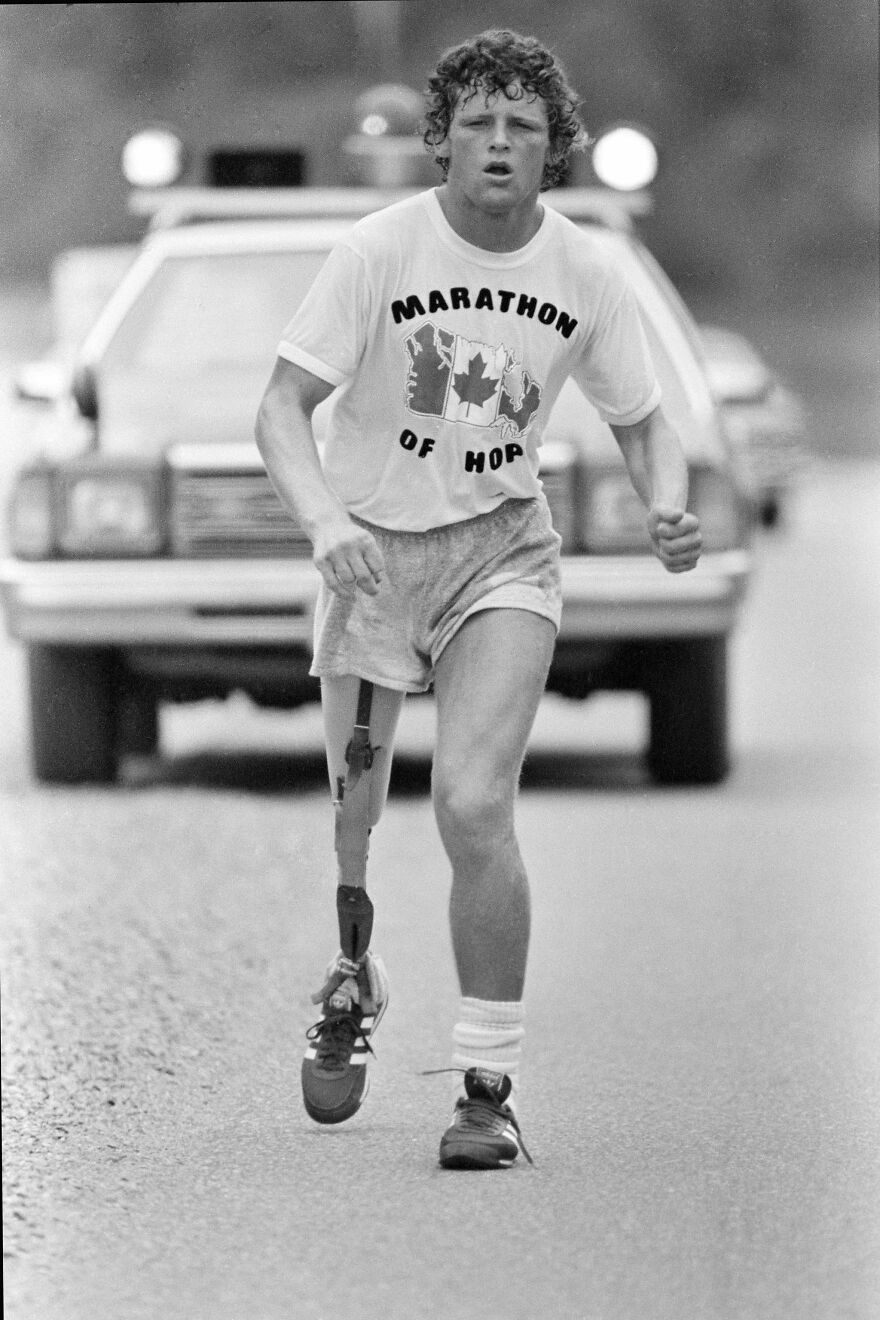 Young athlete with prosthetic leg running a marathon wearing a Marathon of Hope shirt, symbolizing gigachads determination.