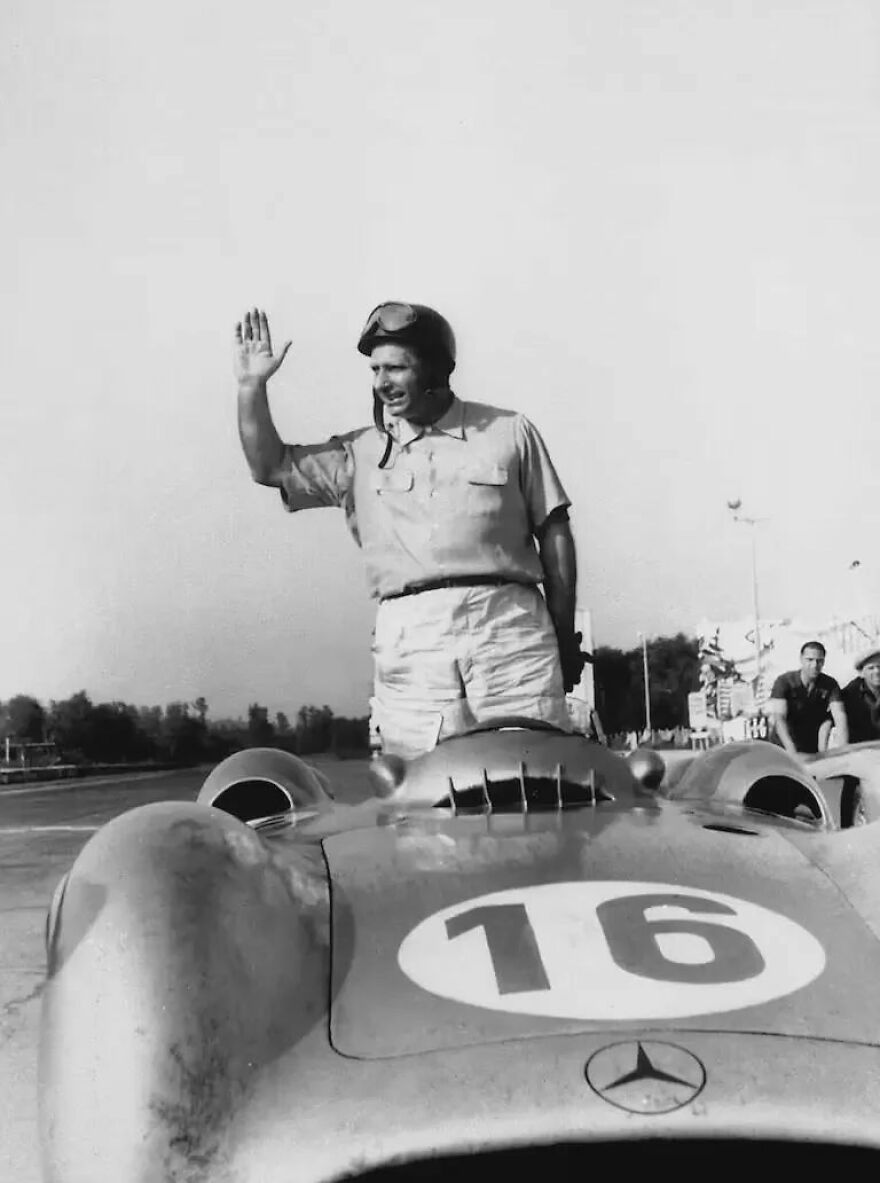 Race car driver standing and waving on vintage Mercedes car number 16, representing iconic gigachads admired worldwide.