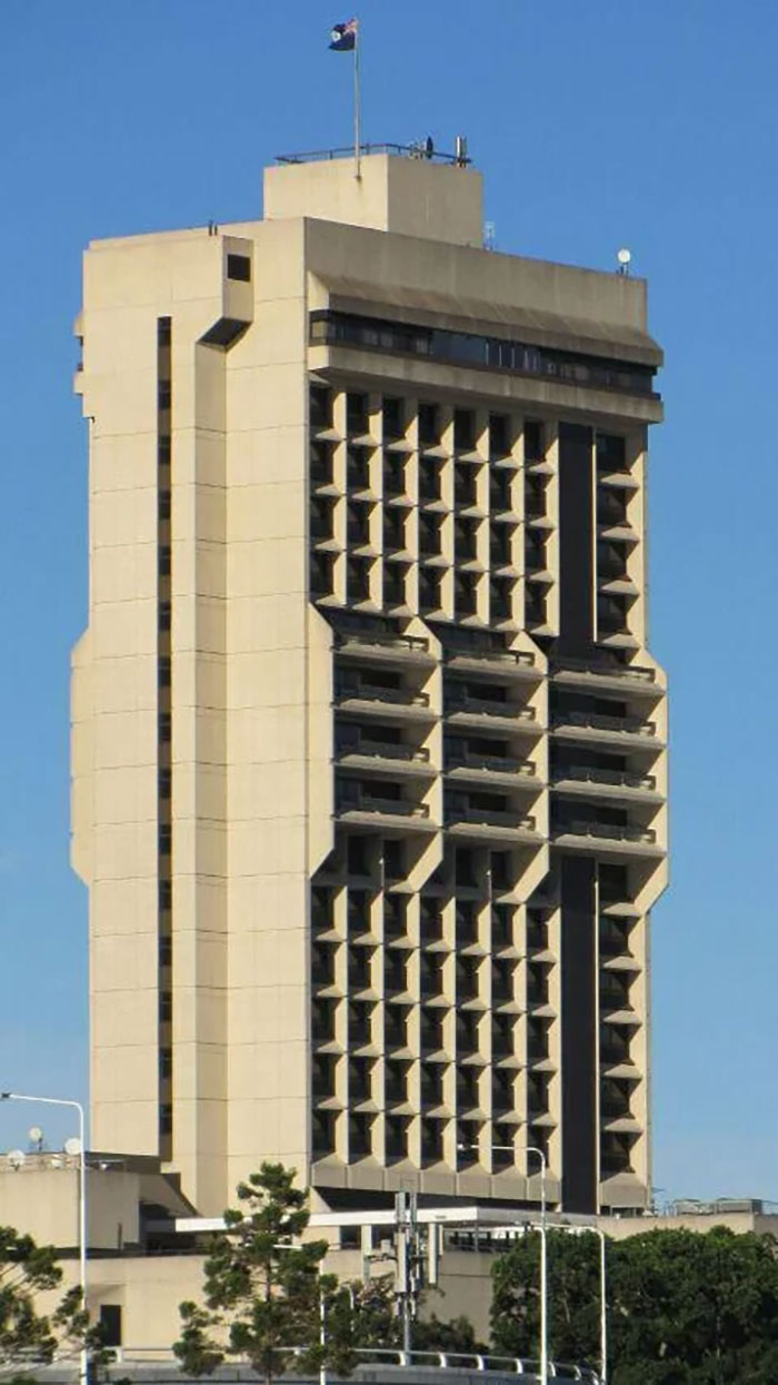 Brutalist architectural malpractice building with harsh geometric patterns, controversial design among locals and costly construction.