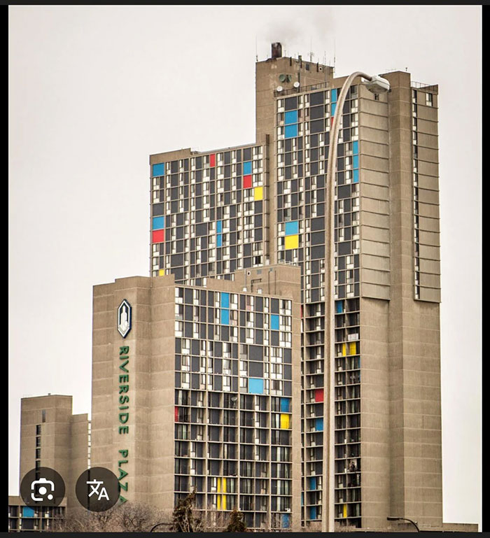 Brutalist architectural malpractice in Riverside Plaza building with colorful window panels in urban setting.