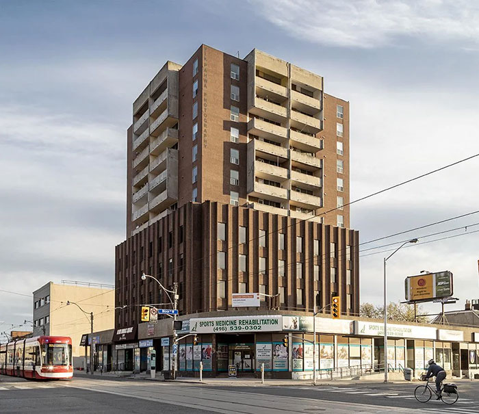 Multistory building with dated architecture and shops below, an example of architectural malpractice costing millions.