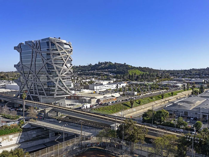 Modern architectural malpractice seen in a controversial building with unusual exterior design near highways and industrial area.