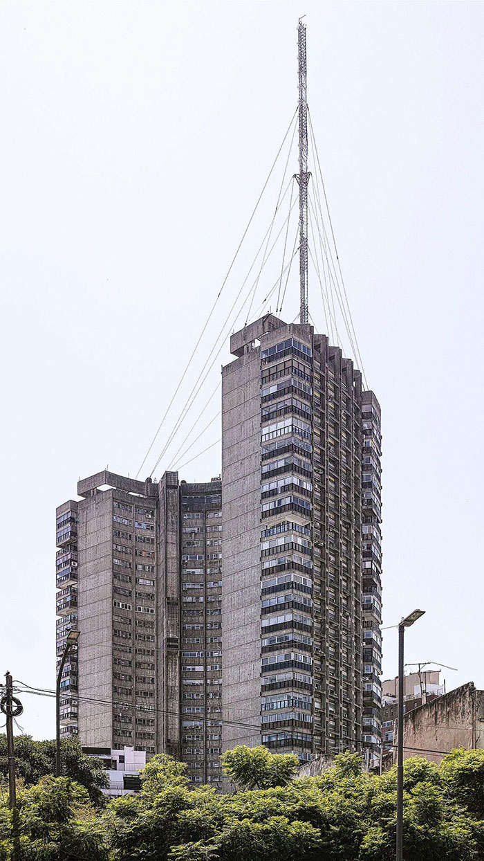 Brutalist high-rise building with an antenna tower, an example of architectural malpractice and controversial ugly buildings.