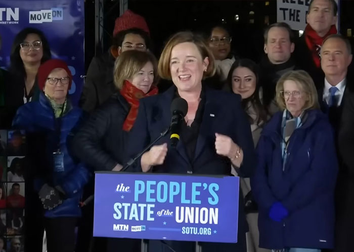 Speaker at a podium labeled People's State of the Union addressing a diverse crowd during viral moments from the State of the Union event