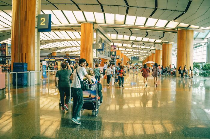 Busy airport terminal with travelers and luggage carts, illustrating facts that may come in clutch during conversations.