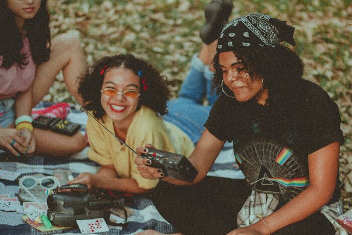 Three friends enjoying outdoor activities with vintage gadgets, capturing the spirit of 80s and 90s pop culture nostalgia.