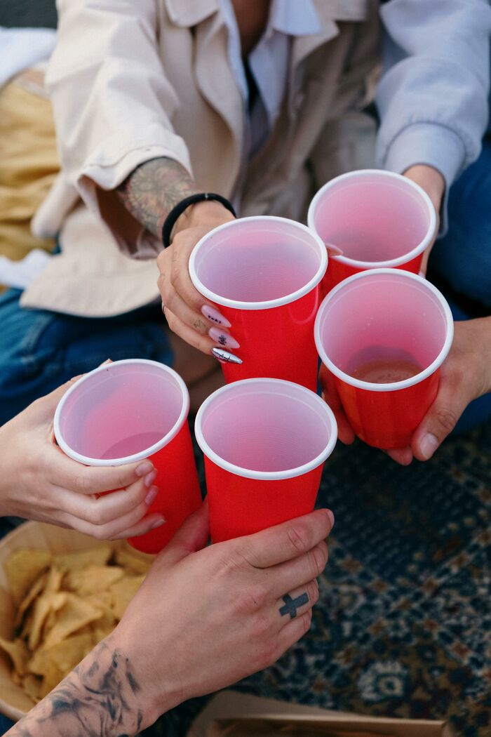 People toasting with red cups at a casual gathering, illustrating things they do and have in their country not common everywhere.
