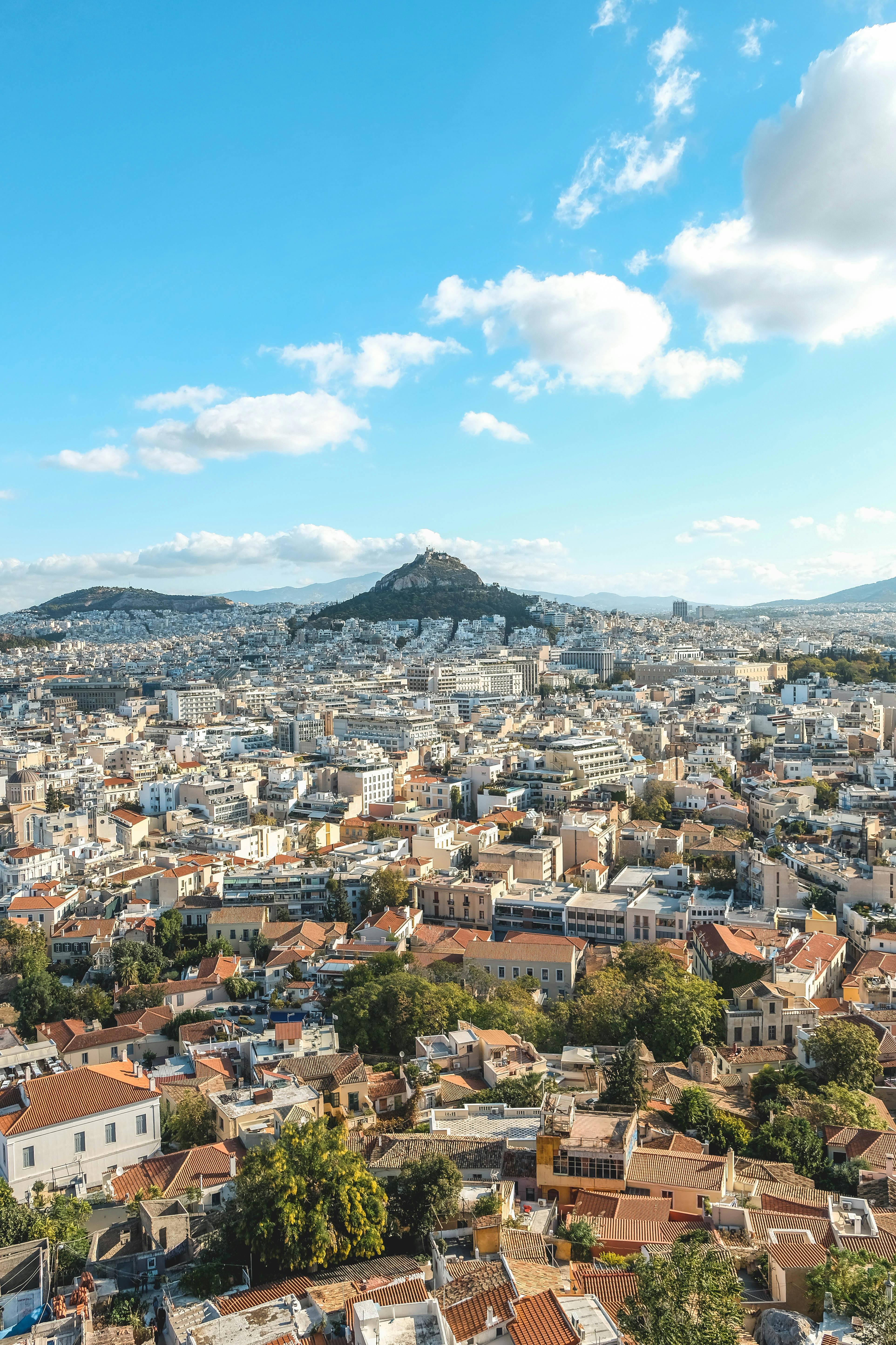 Aerial view of a city under a blue sky, illustrating living out of a suitcase and questioning successful life. Aerial view of a city under a blue sky, illustrating living out of a suitcase and questioning successful life.