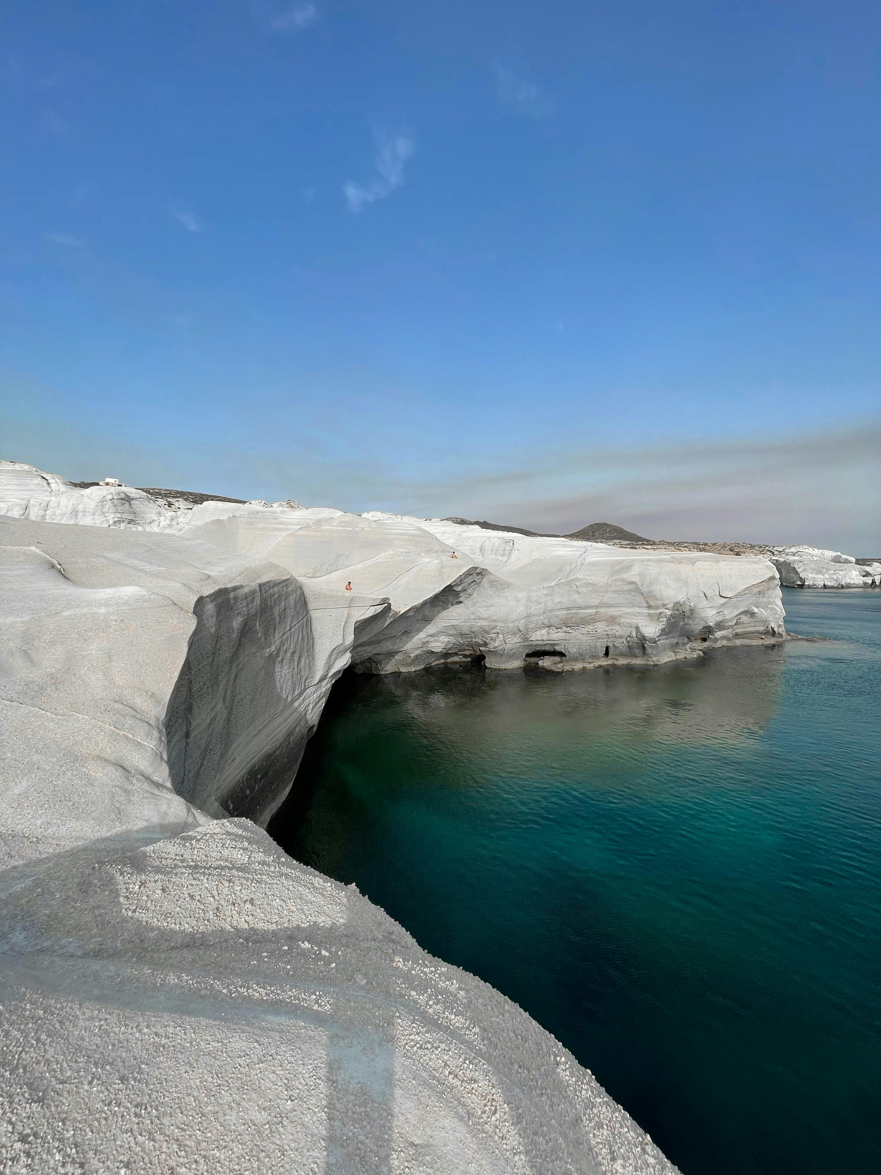 White rocky coastal cliffs beside clear blue water under a sunny sky representing living out of a suitcase lifestyle. White rocky coastal cliffs beside clear blue water under a sunny sky representing living out of a suitcase lifestyle.