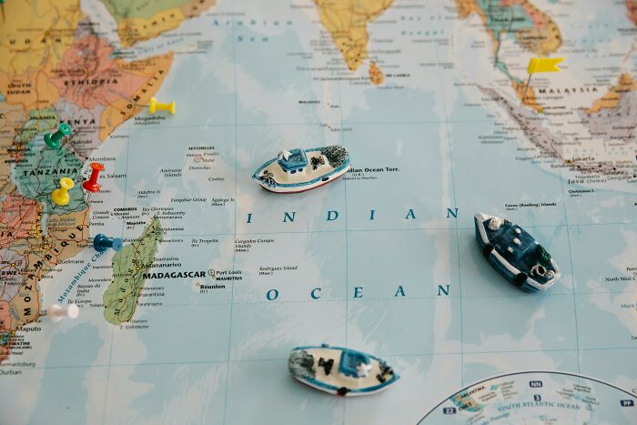 Map of the Indian Ocean with colorful pins and miniature boats highlighting geography quiz locations.