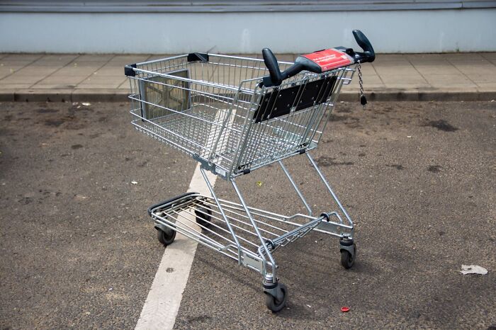 Empty shopping cart abandoned in a parking lot symbolizing people silently judging others based on everyday actions.