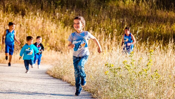 Children running a race outdoors, illustrating common behaviors people silently judge in everyday situations.