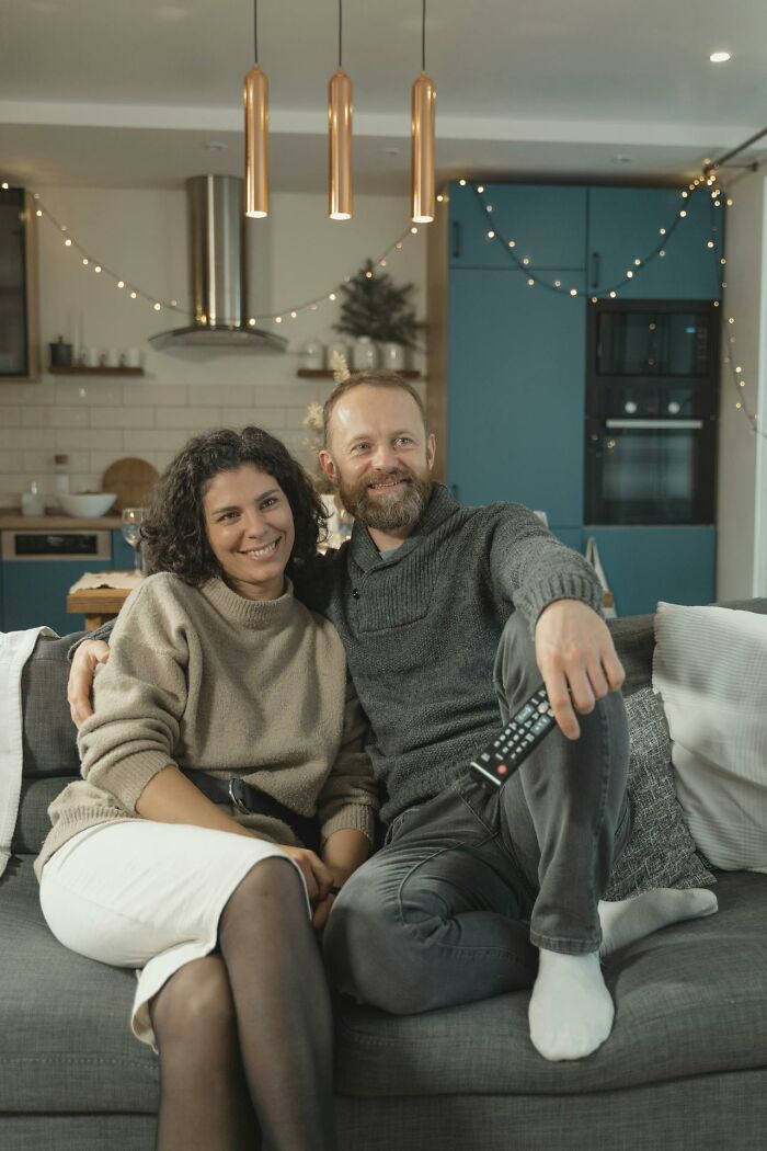 Married couple relaxing on couch in cozy living room, illustrating respect in relationships and partner reactions.