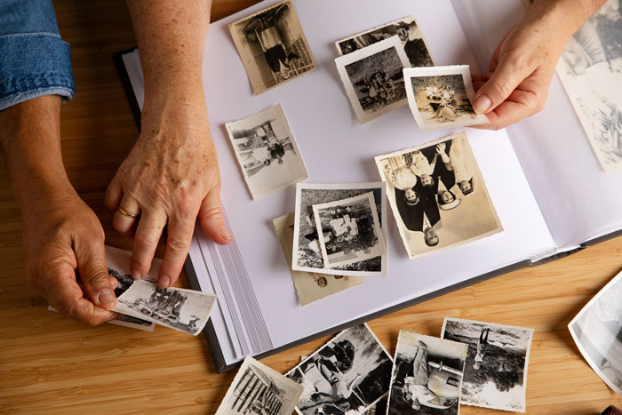 Hands of elderly people reviewing old black and white photos in an album, reflecting memories of mother and family moments. Hands of elderly people reviewing old black and white photos in an album, reflecting memories of mother and family moments.