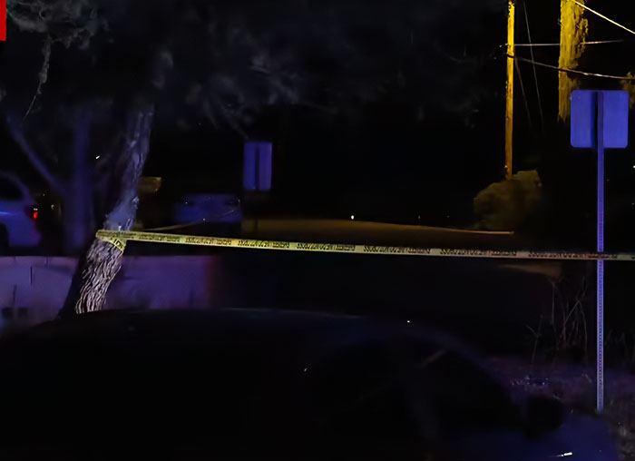 Police tape blocking a dark street at night as man detained in connection with Nancy Guthrie kidnapping remains under investigation.