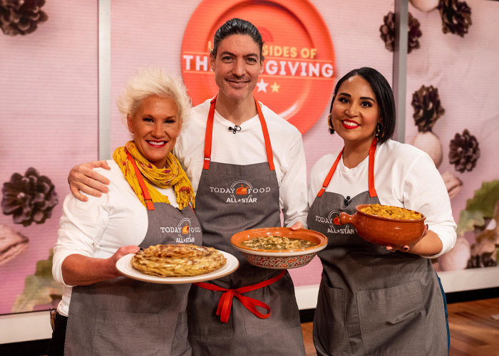 Three chefs wearing aprons holding dishes in a cooking show kitchen, related to police report and tragic passing news. Three chefs wearing aprons holding dishes in a cooking show kitchen, related to police report and tragic passing news.