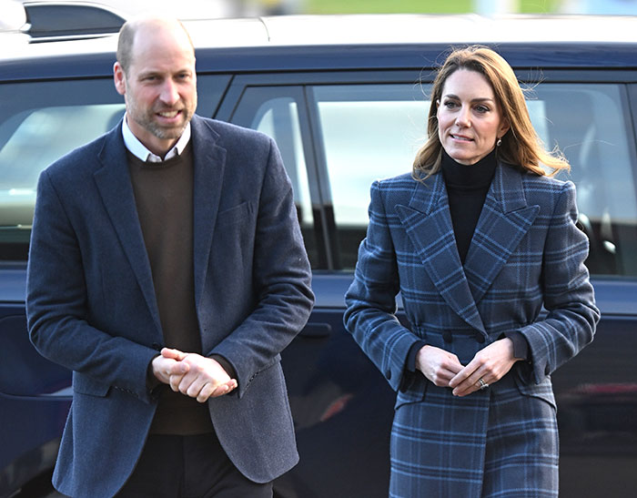 Prince William and Kate Middleton wearing coats, walking outdoors amid rising royal scrutiny related to Epstein files.