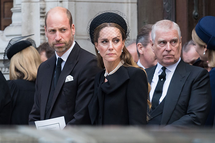 Prince William and Kate Middleton wearing black outfits, attending a formal event amid royal scrutiny.