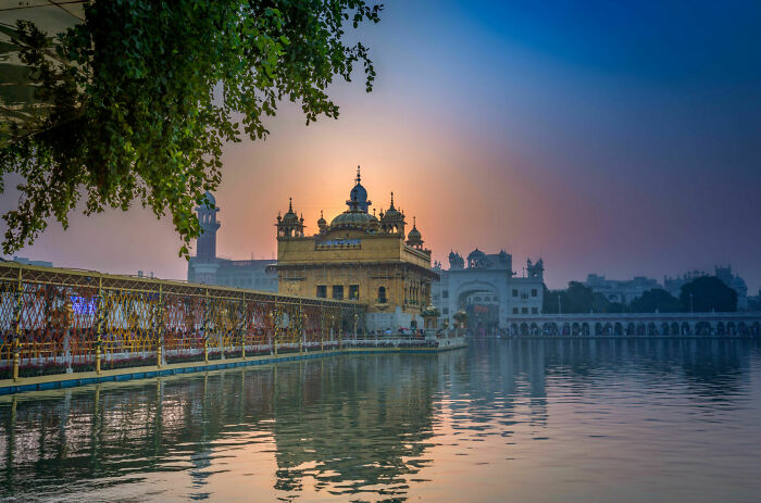 Golden Temple in Amritsar at sunset, reflecting on water, illustrating spiritual tourism in India&rsquo;s sacred sites.