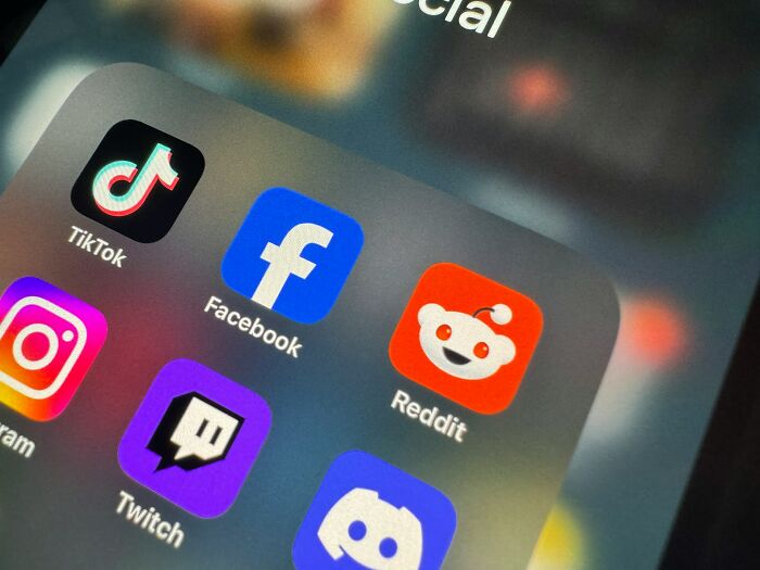 Close-up of popular social media apps on a phone screen, illustrating platforms often linked to funny and harmless conspiracy theories.