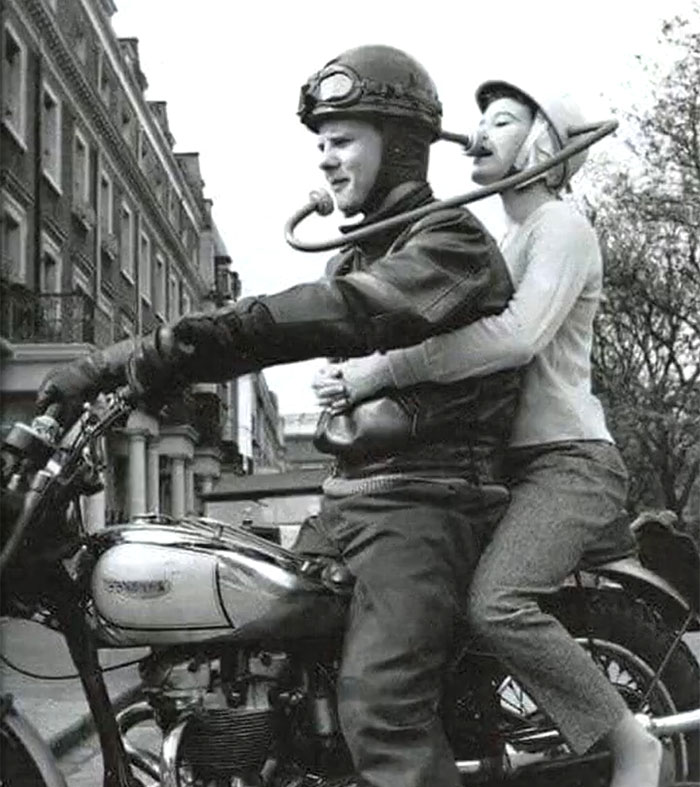 Vintage black and white photo of a couple on a motorcycle with a rare and intriguing historical moment captured.