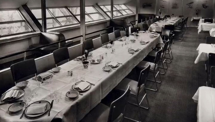 Rare historical photo of a long dining table set for a formal meal, showcasing intriguing moments between the headlines.