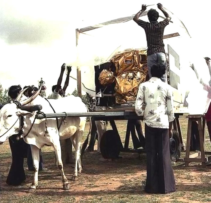 Villagers setting up a rare and intriguing photo of a homemade lunar rover mock-up between the headlines.
