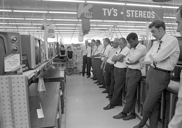 Men in a store looking at early TV sets, illustrating rare and intriguing photos from history between the headlines.