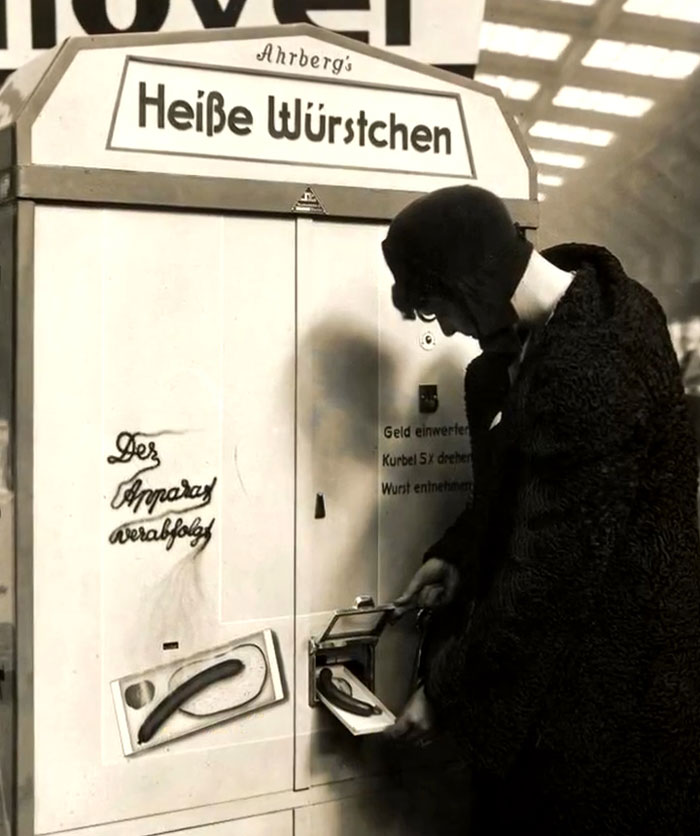 Vintage photo of a woman using a rare sausage vending machine, showcasing intriguing history between the headlines.