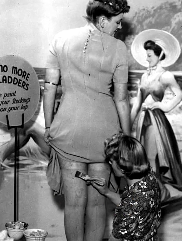 Woman having stockings painted on during a rare historical moment, showcasing intriguing history between the headlines.