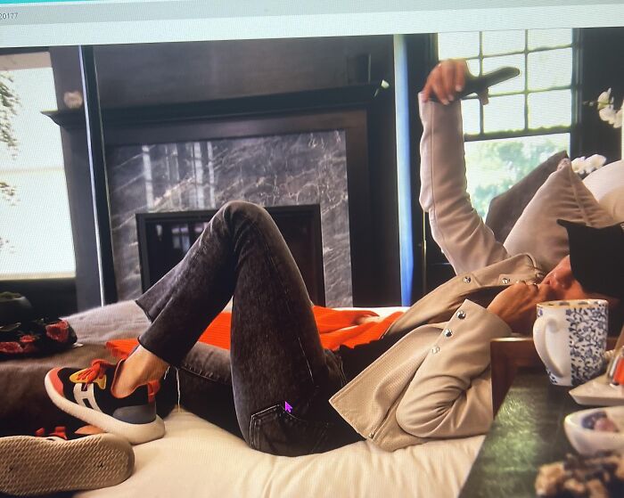 Person lying on a bed in a modern living room illustrating red flags in someone’s home environment.