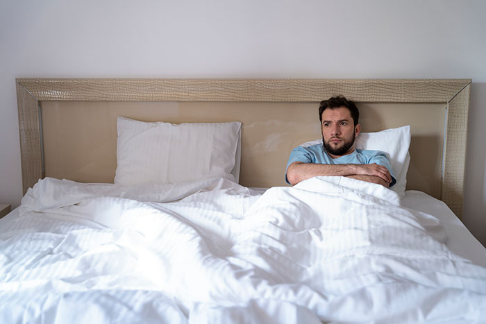 Sick man in bed looking upset, illustrating man learns in sickness and in health is a lie concept. Sick man in bed looking upset, illustrating man learns in sickness and in health is a lie concept.