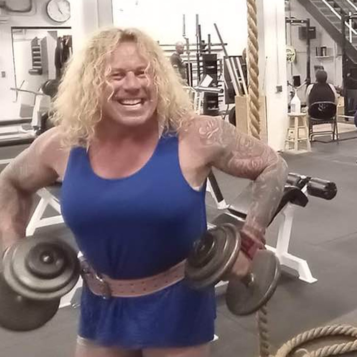 Muscular person lifting dumbbells in gym, representing family of trans mom Roberta Dorgan after Rhode Island hockey tragedy.