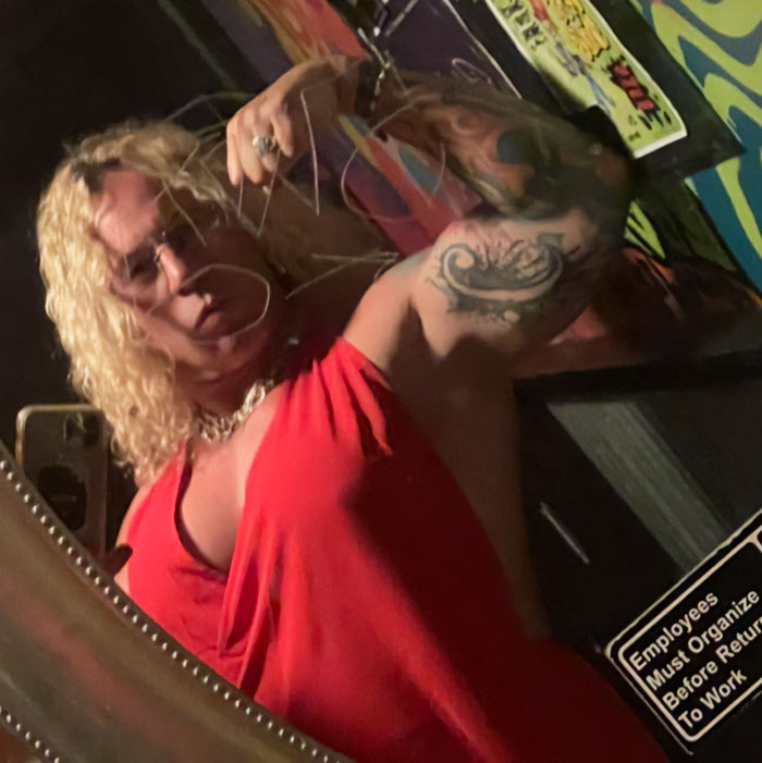 Person with curly blond hair wearing a red top showing tattooed arm, related to disturbing criminal history of Roberta Esposito's son. Person with curly blond hair wearing a red top showing tattooed arm, related to disturbing criminal history of Roberta Esposito's son.