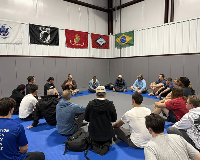 Group of people sitting in a circle indoors during a gathering unrelated to Russell Brand baptism or charges news.