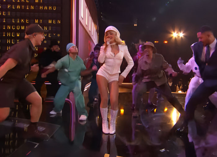 Sabrina Carpenter performing at the 2026 Grammys surrounded by dancers in a dynamic stage show.