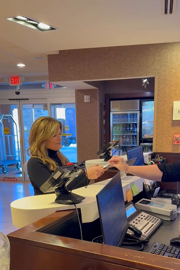 Woman receiving a card at a hotel front desk illustrating safety tips for women from a former FBI agent.