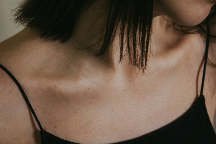 Close-up of a woman’s neck and shoulder wearing a black spaghetti strap top, conveying emotions tied to friendship ending stories.