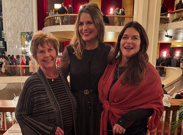 Three women smiling indoors at an event, related to Savannah Guthrie&rsquo;s brother-in-law and missing mom case.