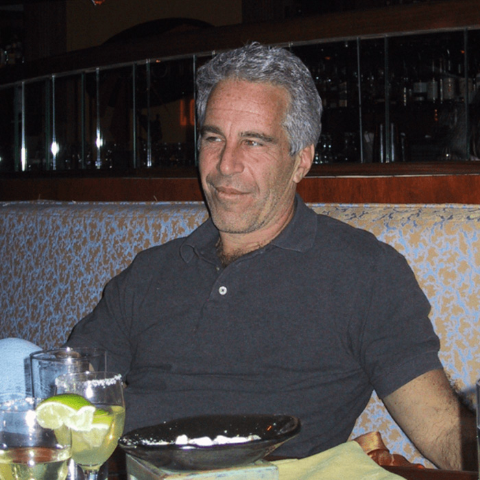 Man with gray hair sitting in a restaurant booth with drinks and plates, related to Epstein files and school cancellations. Man with gray hair sitting in a restaurant booth with drinks and plates, related to Epstein files and school cancellations.