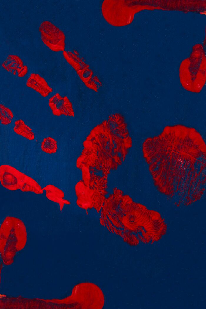 Red handprints smeared across a dark blue wall, evoking eerie and strange experiences of graveyard shift workers.