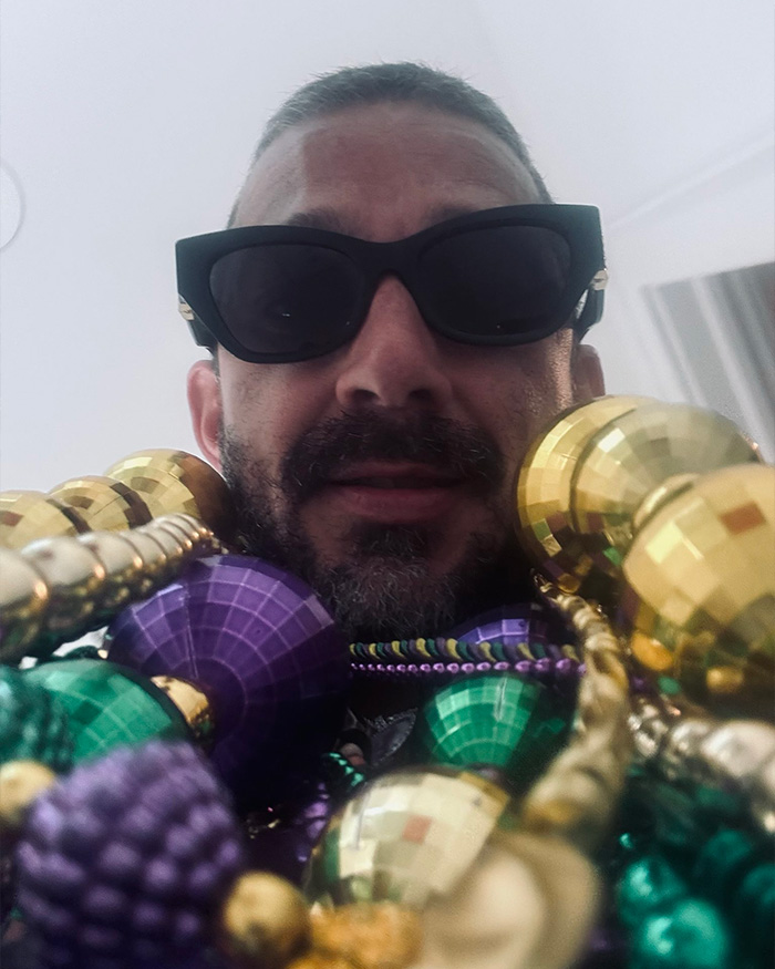 Shia LaBeouf wearing sunglasses and Mardi Gras beads, related to New Orleans arrest and sobriety break news.