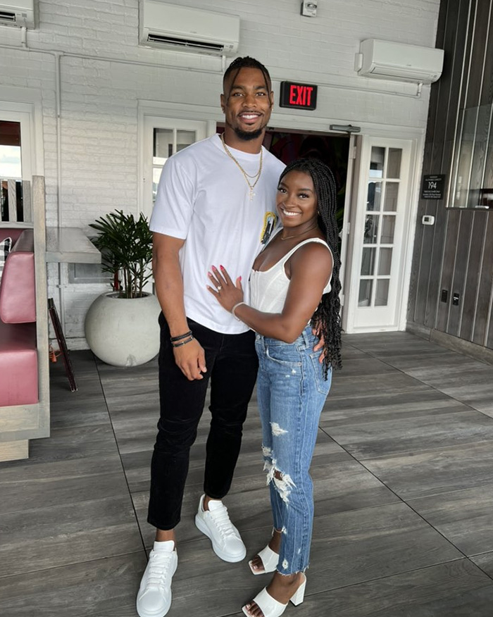 Simone Biles and NFL husband posing indoors, smiling, highlighting their experience as victims of unsettling crime.