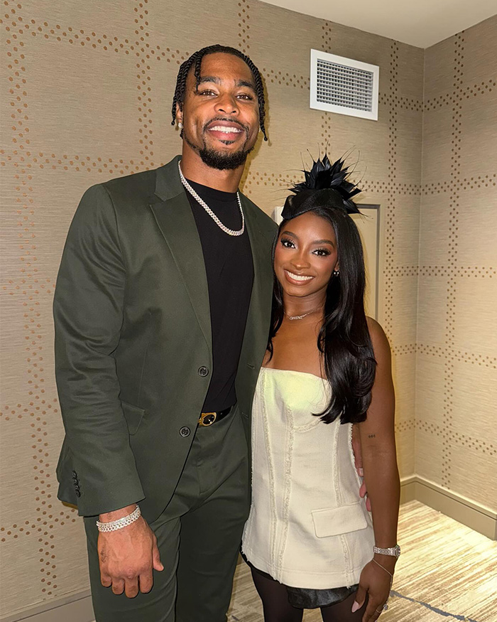Simone Biles and NFL husband smiling together indoors during Winter Olympics visit, victims of unsettling crime.