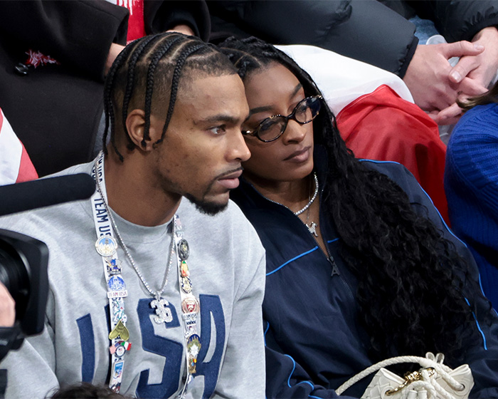 Simone Biles and NFL husband sitting together at a Winter Olympics event amid unsettling crime news.