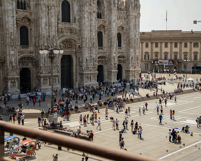 Crowd gathered outside a historic cathedral, highlighting Simone Biles and NFL husband as crime victims during Winter Olympics.